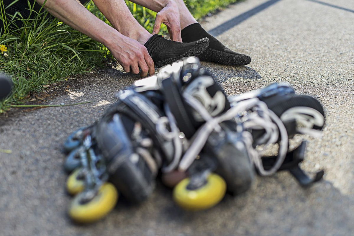 Skinners Sockenschuh beim Anziehen neben Inline-Skates